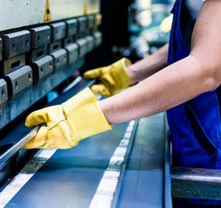 Worker-using-machinery-in-metal-plant